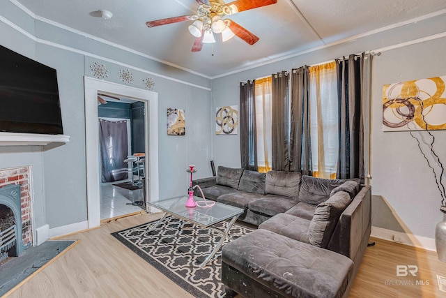 living room with wood-type flooring, ornamental molding, and ceiling fan