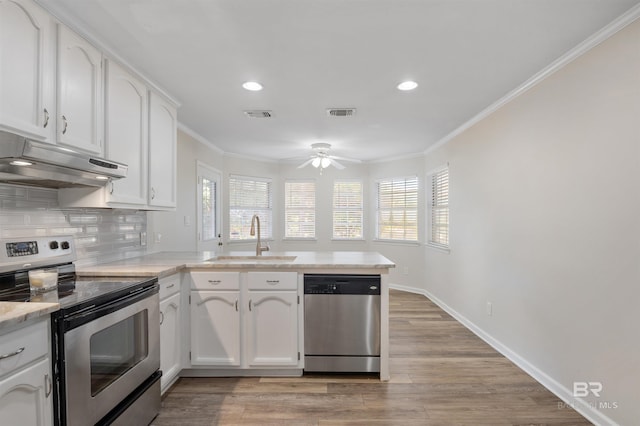 kitchen featuring white cabinetry, sink, light hardwood / wood-style floors, and appliances with stainless steel finishes