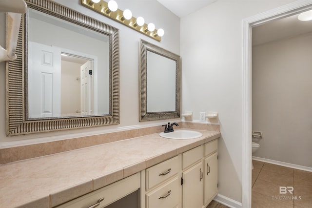 bathroom with tile patterned flooring, vanity, and toilet