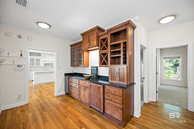 kitchen with wood-type flooring, crown molding, and sink