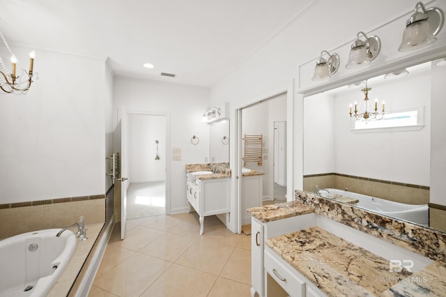 bathroom with ornamental molding, tiled tub, vanity, and tile patterned floors