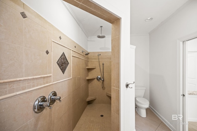 bathroom with ornamental molding, toilet, a tile shower, and tile patterned floors