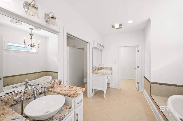 bathroom with a tub to relax in, tile patterned floors, crown molding, vanity, and toilet