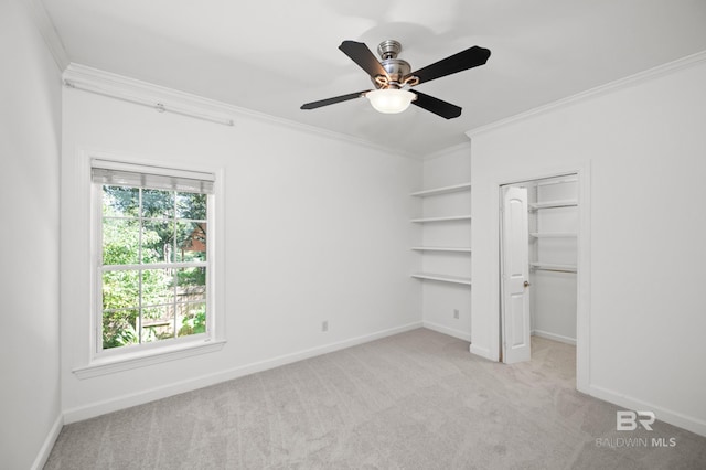 unfurnished bedroom with ornamental molding, a closet, ceiling fan, and light colored carpet