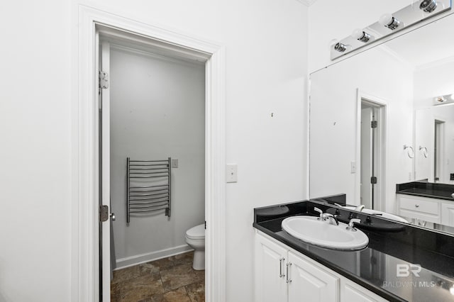 bathroom featuring ornamental molding, vanity, and toilet