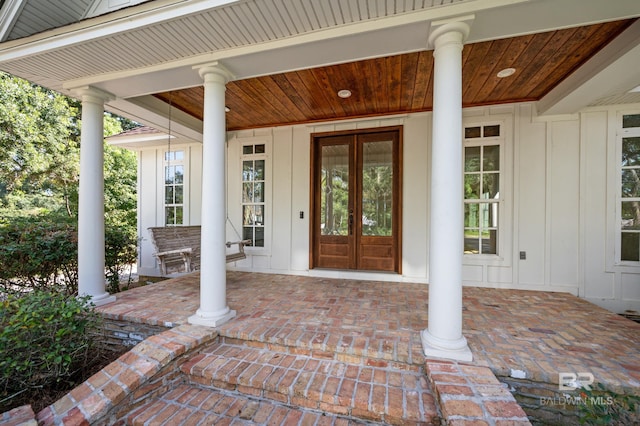 doorway to property with a porch and french doors