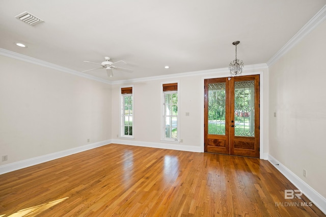 entryway with crown molding, ceiling fan with notable chandelier, light hardwood / wood-style flooring, and french doors