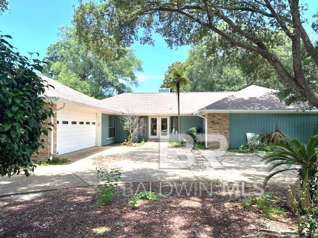 1417 E Fairway Dr, Gulf Shores, AL 36542 - single story home with an attached garage, french doors, driveway, and brick siding