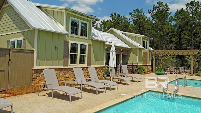 rear view of property with a pergola, a fenced in pool, and a patio