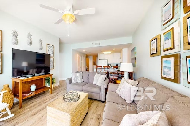 living room with light hardwood / wood-style floors and ceiling fan