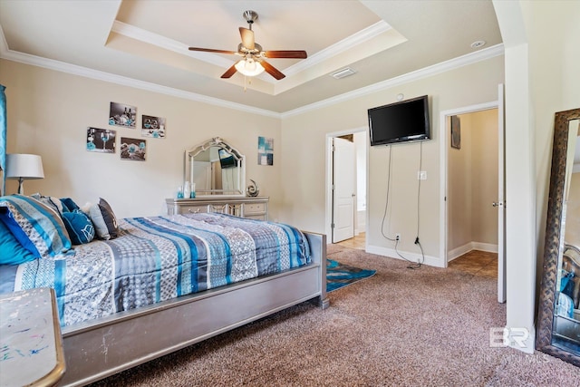 bedroom with crown molding, a tray ceiling, carpet floors, and ceiling fan