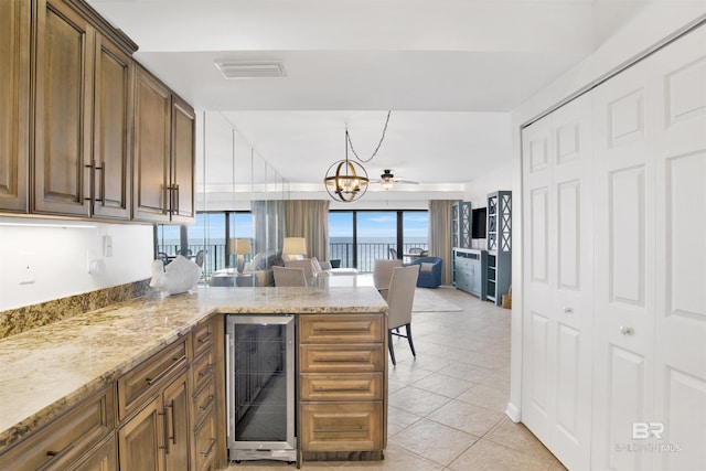 kitchen featuring wine cooler, light tile patterned floors, visible vents, open floor plan, and a peninsula