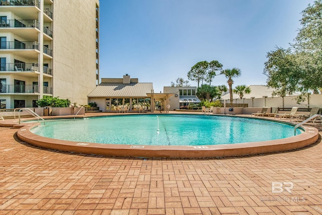 pool with a patio and fence