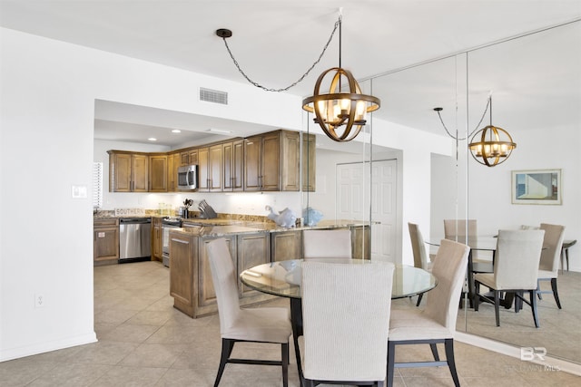 kitchen featuring stone counters, stainless steel appliances, visible vents, a chandelier, and a peninsula