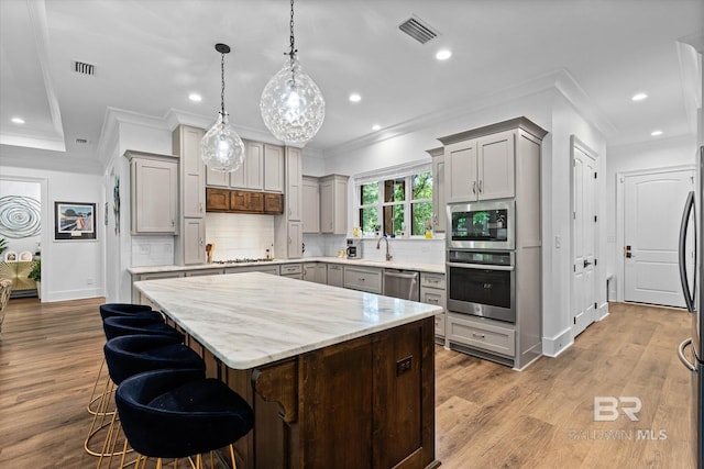 3250 Riviere Du Chien Rd, Mobile, AL 36693 - kitchen with appliances with stainless steel finishes, gray cabinets, ornamental molding, a center island, and backsplash