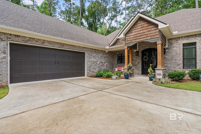 3250 Riviere Du Chien Rd, Mobile, AL 36693 - view of front of house featuring a shingled roof, brick siding, driveway, and an attached garage