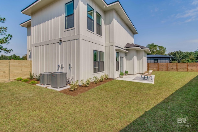 rear view of property featuring a patio, a lawn, and central air condition unit