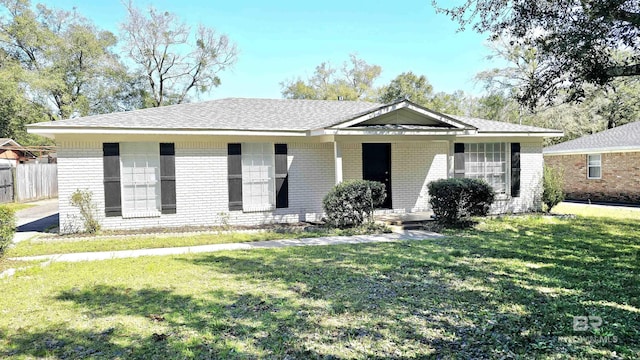 single story home with brick siding, fence, and a front lawn