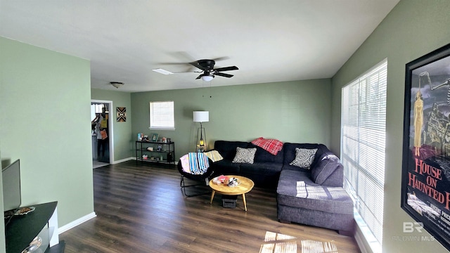 living area featuring dark wood-style flooring, a ceiling fan, and baseboards