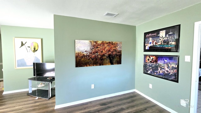 interior space with wood finished floors, visible vents, and baseboards