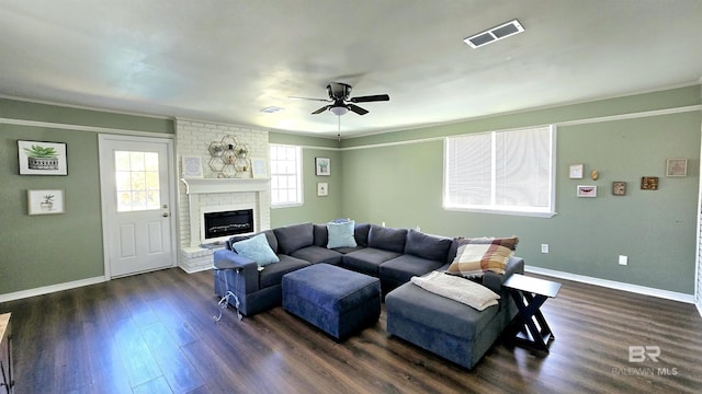 living room with a fireplace, dark wood finished floors, visible vents, and baseboards