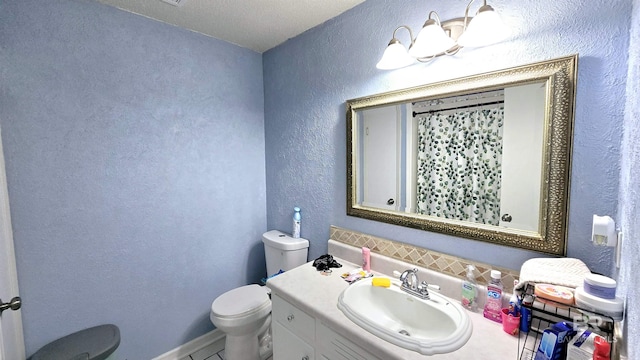 full bath with curtained shower, a textured wall, vanity, and toilet