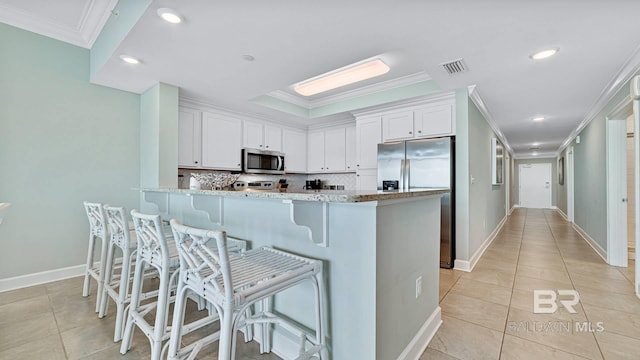 26688 Perdido Beach Blvd Unit 1203, Orange Beach, AL 36561 - kitchen featuring appliances with stainless steel finishes, crown molding, white cabinetry, backsplash, and light stone counters