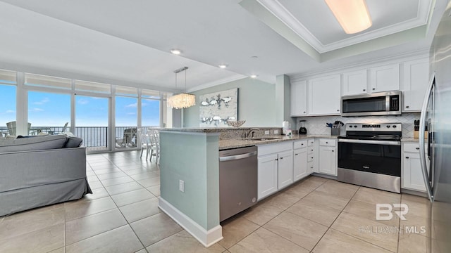 26688 Perdido Beach Blvd Unit 1203, Orange Beach, AL 36561 - kitchen featuring stainless steel appliances, white cabinetry, tasteful backsplash, crown molding, and a peninsula