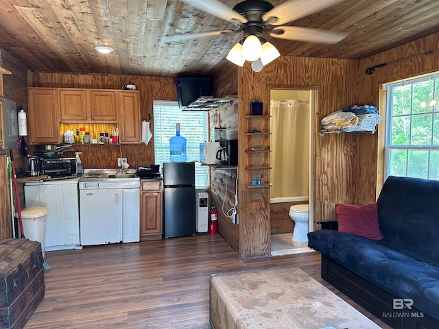 kitchen with stainless steel fridge, dark hardwood / wood-style flooring, wooden ceiling, and wood walls