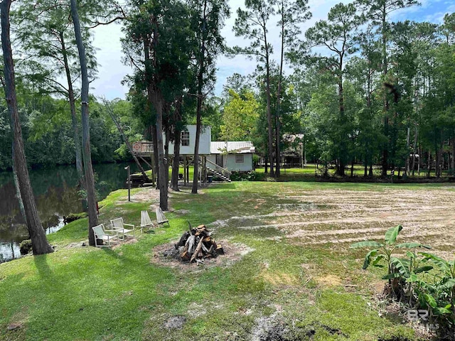 view of yard with a fire pit and a water view