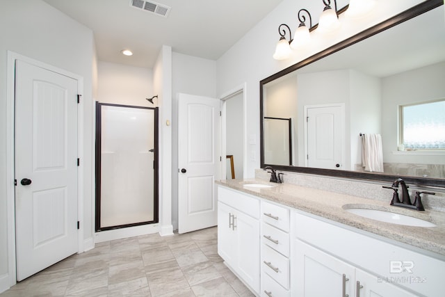 full bathroom with a sink, a shower stall, double vanity, and visible vents