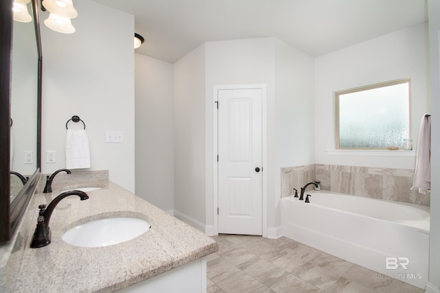 bathroom featuring a garden tub, a sink, baseboards, and double vanity
