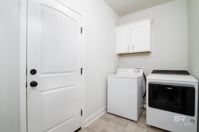 laundry area featuring baseboards, cabinet space, and independent washer and dryer