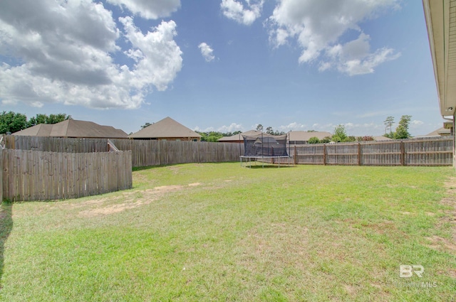 view of yard with a fenced backyard and a trampoline