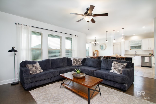 living area with recessed lighting, light wood-style flooring, and ceiling fan with notable chandelier