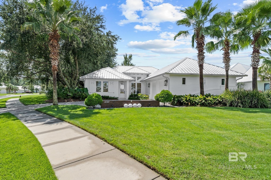 4067 Muirfield Ct, Gulf Shores, AL 36542 - view of front of home with a garage, a standing seam roof, a front yard, and metal roof