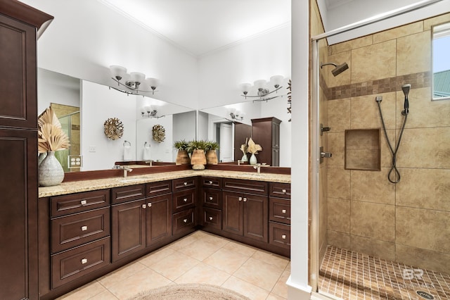 full bathroom with double vanity, crown molding, a tile shower, a sink, and tile patterned floors
