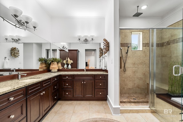 bathroom featuring vanity, a shower with shower door, ornamental molding, and tile patterned floors