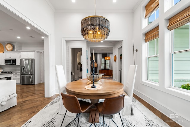 dining room with an inviting chandelier, ornamental molding, dark hardwood / wood-style flooring, and plenty of natural light