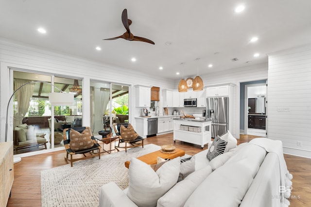 living area featuring a ceiling fan, recessed lighting, light wood-style flooring, and visible vents