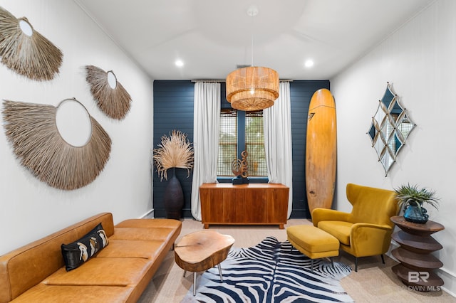 sitting room featuring wooden walls and light carpet