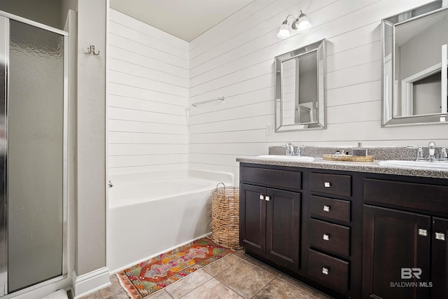 bathroom with tile patterned flooring, wood walls, vanity, and independent shower and bath