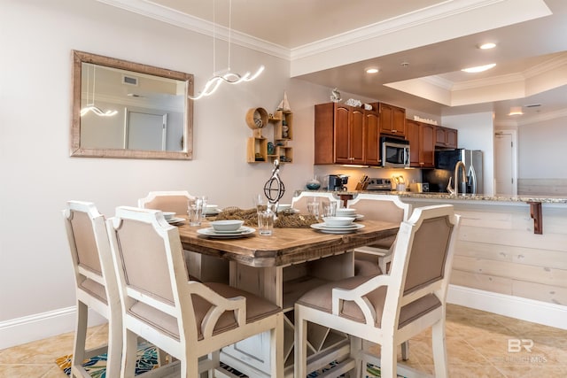 dining room featuring a raised ceiling, light tile patterned floors, and crown molding