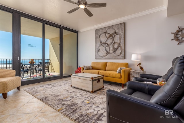 tiled living room featuring ceiling fan, a wall of windows, and ornamental molding