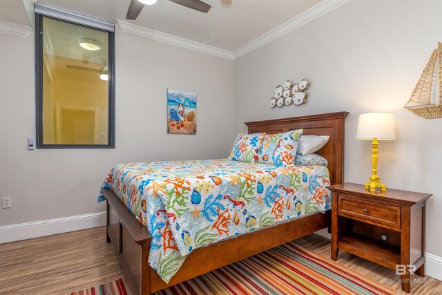 bedroom with wood-type flooring, ceiling fan, and crown molding