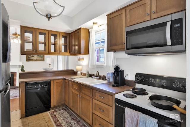 kitchen with appliances with stainless steel finishes, light tile patterned floors, and sink