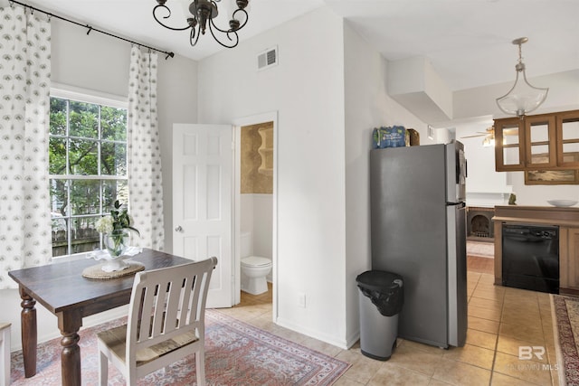 tiled dining room with ceiling fan with notable chandelier