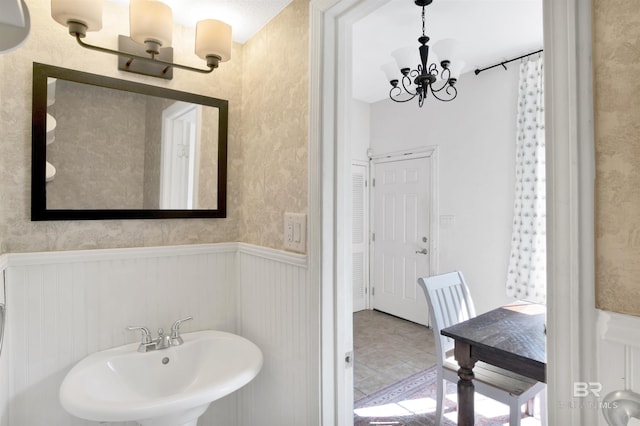 bathroom featuring sink and a chandelier