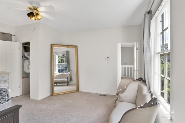 sitting room featuring ceiling fan and light colored carpet