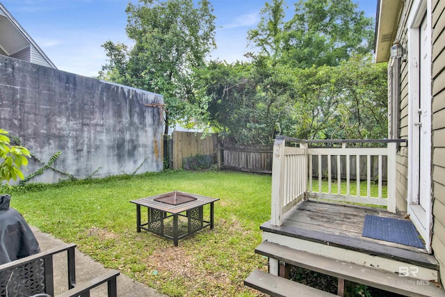 view of yard featuring a deck and an outdoor fire pit